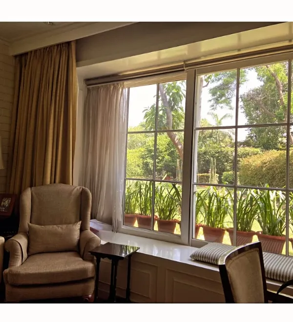 This serene sitting area is bathed in natural light from a large picture window. We designed a comfortable window seat to invite residents to pause and enjoy the view of the lush garden just outside.