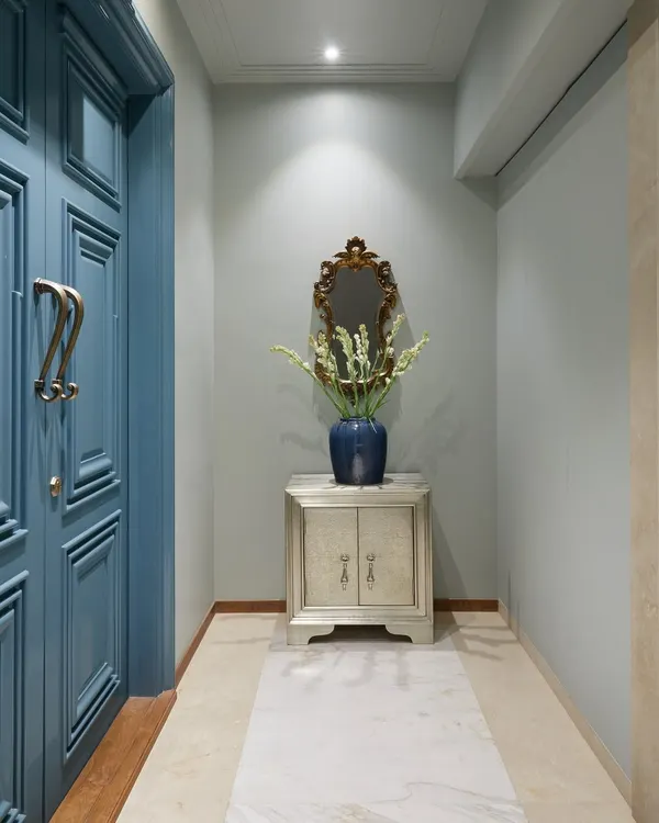 For the Bhanushali residence, I transformed the building's lift lobby into a personal foyer. By painting over existing panels and adding a refurbished console and vintage mirror from the client's previous home, I created a welcoming space that feels both new and familiar.