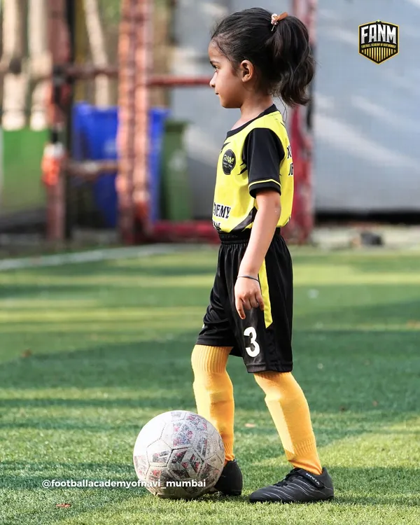 A young girl stands confidently with her foot on the ball, ready for her training session. I welcome players of all ages and genders, starting from the very basics.