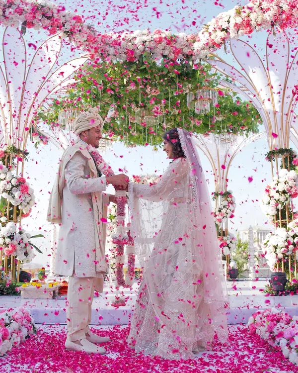 A truly magical varmala moment, where the couple is showered in a rain of pink petals under a breathtaking floral mandap. This is the kind of unforgettable, picture perfect scene I love to create.