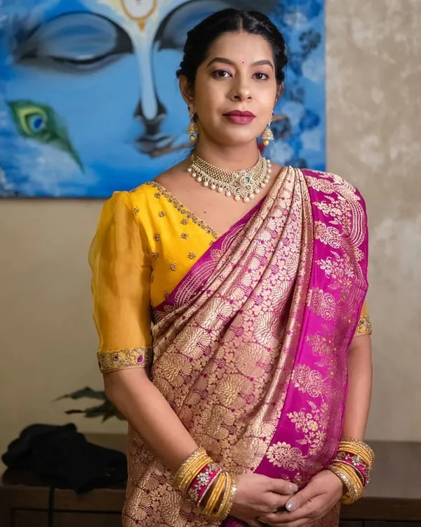 A beautiful mother-to-be in a yellow and pink Kanchipuram saree. Her custom yellow blouse with puffed sleeves was designed for both comfort and style during her baby shower.