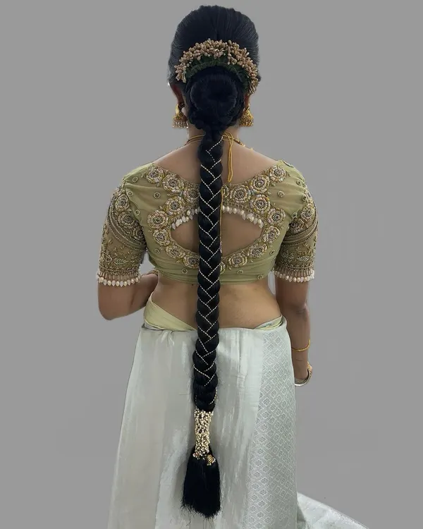A stunningly intricate bridal braid, woven with pearls for a modern yet traditional muhurtham hairstyle. This look is all about detailed craftsmanship.