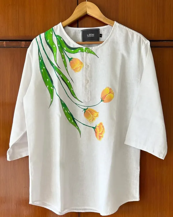 A closer look at a custom hand-painted linen kurta. The yellow tulip design flows organically from the neckline, making the garment a unique piece of floral art you can wear.