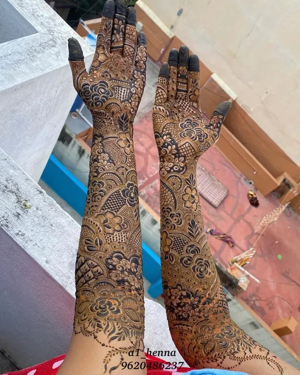 Full-arm bridal henna for Salma, showcasing a blend of Pakistani and floral styles. The design features detailed flowers, paisleys, and geometric fills for a breathtaking result.