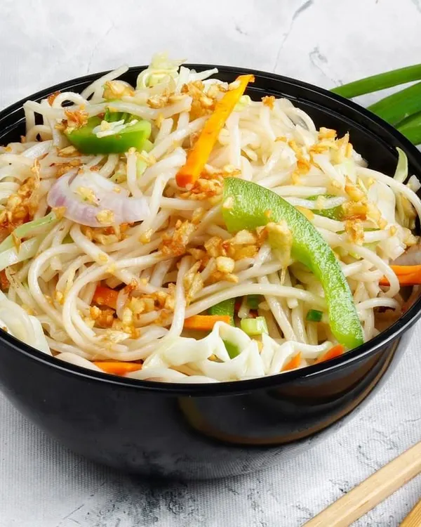 A bowl of our simple yet delicious Garlic Noodles. The noodles are tossed with fried garlic, spring onions, and sliced peppers for a light and aromatic flavour.