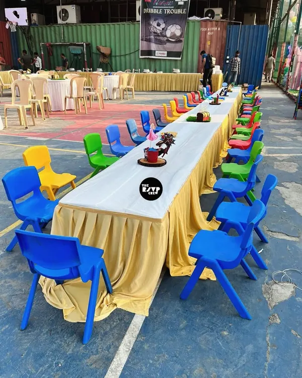 A long table set up just for the kids, with a rainbow of colorful chairs. This ensures the little ones have their own dedicated space to eat and play.