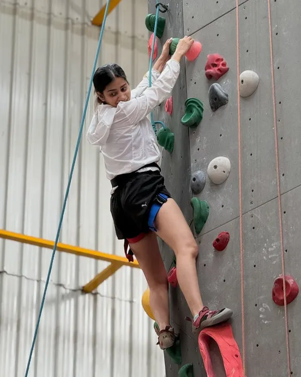 A climber focuses as she makes her way up a top rope route. Weekends at our gym are filled with good vibes, fun challenges, and great company.