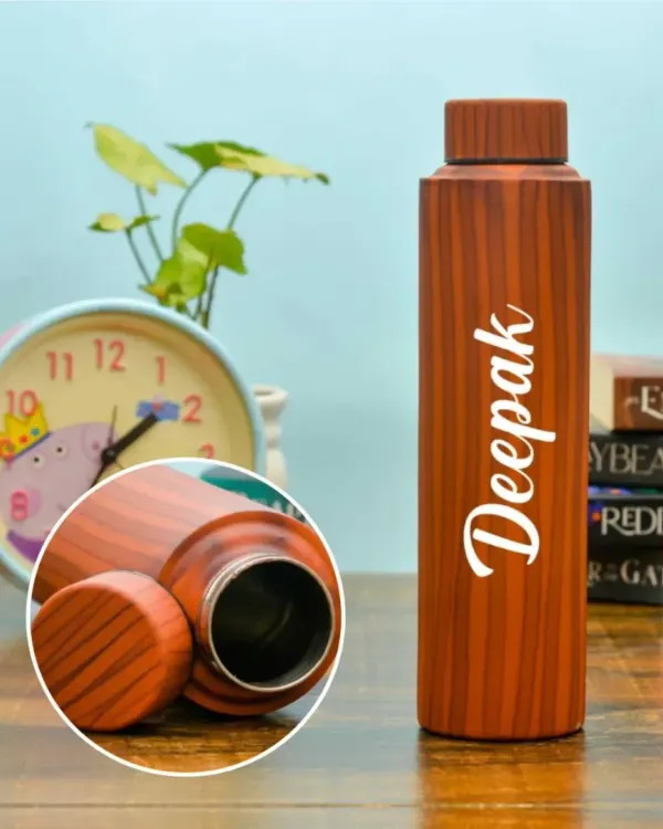 A stainless steel bottle with a stylish wooden finish. It holds 900 ml and can be customized with any name, making it a practical and personal gift.