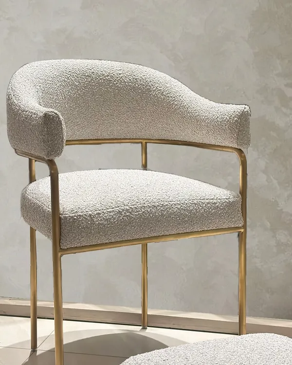 Commissioned for a client, this armchair and matching footrest feature soft bouclé upholstery on a slender, gold-finished frame. The design balances tactile comfort with a minimal silhouette, creating a piece of functional, understated luxury.