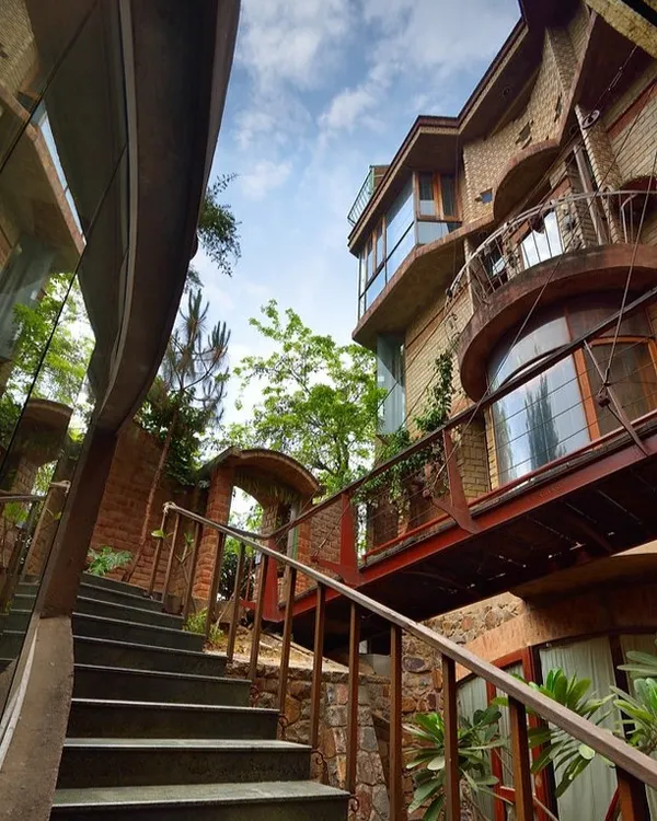 This home is a living example of bioclimatic architecture, designed to work in harmony with nature. The structure is built from Compressed Stabilised Earth Blocks (CSEB) made from the very soil of the site, minimizing our carbon footprint. This low-angle view from the basement level shows how every part of the home, including the stairways and bridges, is designed for natural light and ventilation.