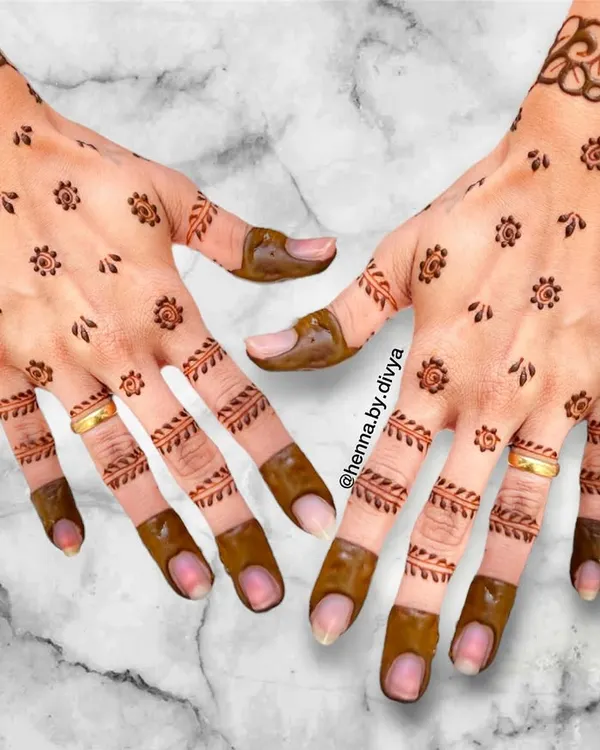 A perfect example of simple and elegant guest mehendi. This design features tiny floral booti patterns scattered across the palm with light leafy details on the fingers, offering a subtle and pretty look.