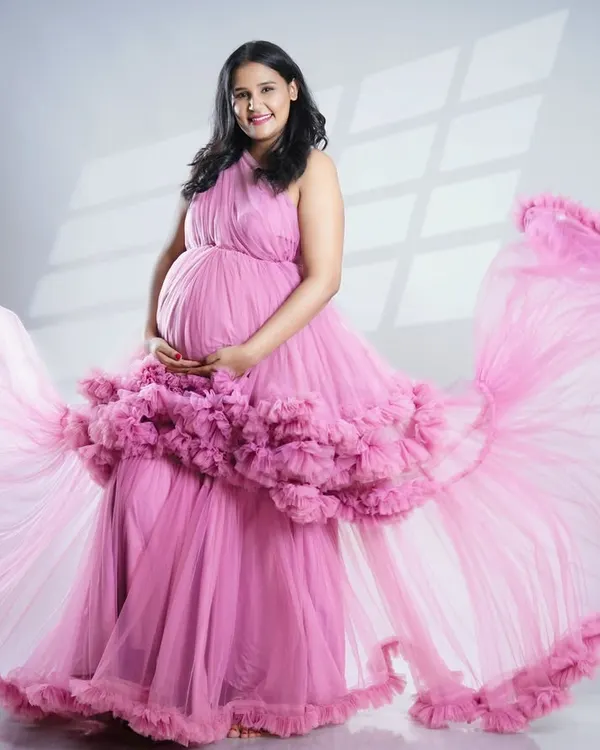 This is one of our most popular flowing tulle gowns, shown here in a lovely pink. The way the fabric catches the light and air creates a truly magical and ethereal portrait, perfect for celebrating your pregnancy.