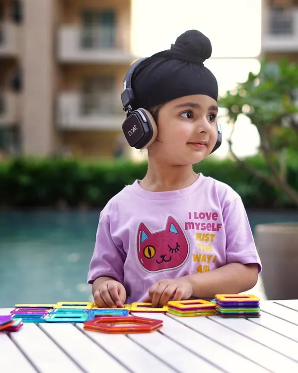 Capturing a moment of focused play. This lifestyle shot for a kids' wear brand feels authentic and highlights the clothing in a natural setting.