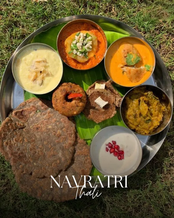 Our signature Navratri Thali, beautifully plated on a banana leaf and served outdoors. It features a complete meal with kuttu ki puri, sabzis, raita, and sweets, all prepared according to vrat guidelines.