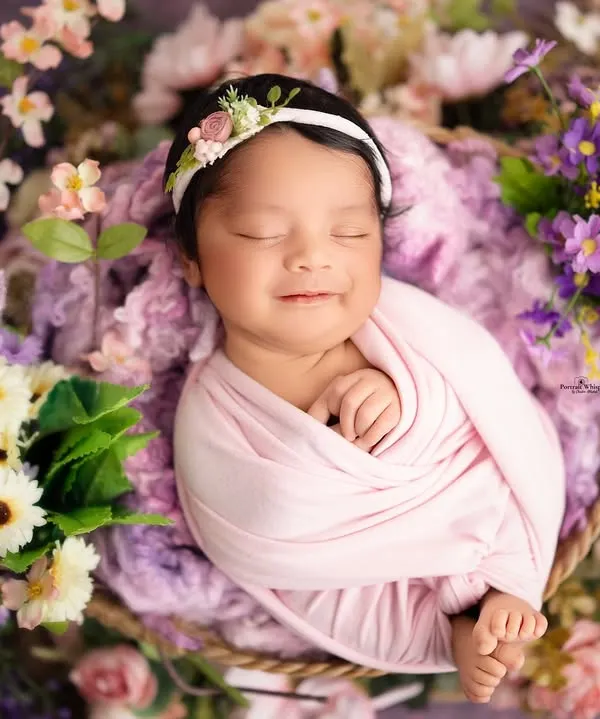 A precious, fleeting smile from this little one, nestled in a basket of soft lavender and pastel flowers. I love capturing these spontaneous moments of joy during my newborn sessions in the studio.