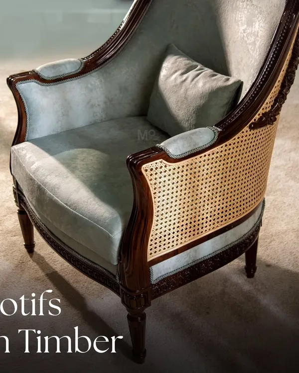 The Motifs on Timber collection celebrates heritage and meticulous craftsmanship. This armchair features intricate chip carving on a dark wood frame, balanced by soft, pastel velvet upholstery and classic caning for a unique design that transcends time.