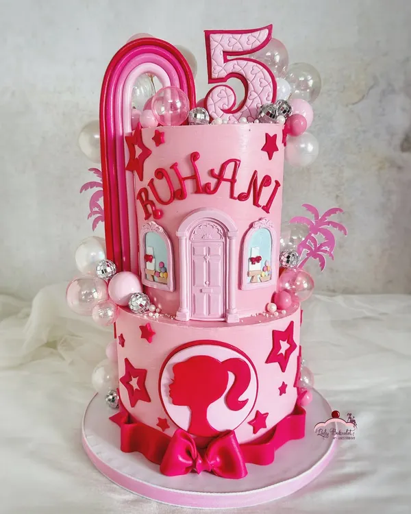 Come on Barbie, let's go party! This two-tier pink dream cake features a Barbie dreamhouse design, a silhouette, and fun disco ball details, perfect for a glamorous celebration.