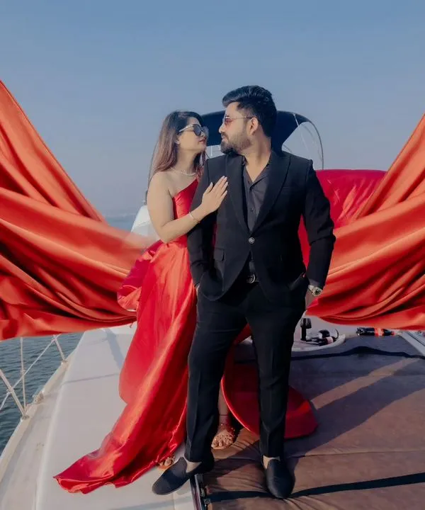 A moment of pure cinematic romance on the open sea in Goa. We believe your love story deserves an epic backdrop, and we travel with you to create these unforgettable scenes. Here, the bride's vibrant red gown flows like wings, a symbol of a love that's ready to take flight.