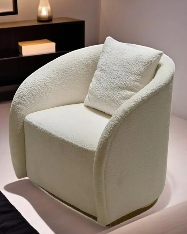 We designed this armchair as an exercise in sculptural comfort. Its curved form and plush bouclé upholstery create an inviting silhouette, offering a piece that is both a comfortable seat and a statement of minimalist luxury.