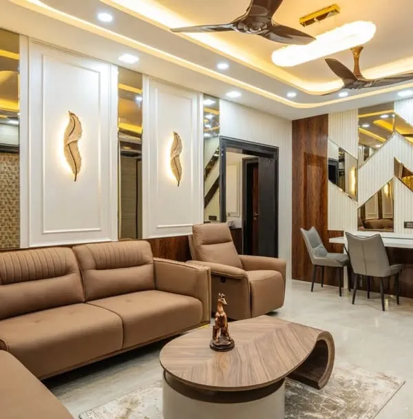 An integrated living and dining space in Mahad, designed for a cohesive look. The design features wood paneling, elegant wall sconces, and a comfortable recliner sofa, all tied together with warm ambient lighting to create a sophisticated and harmonious environment.