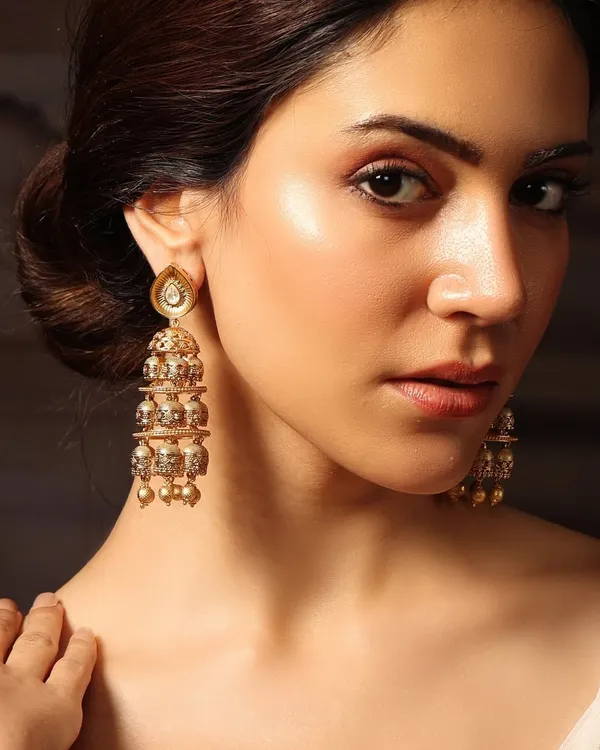 A close-up of our tiered golden jhumkas, worn by Pashmina Roshan, featuring delicate craftsmanship perfect for any celebration.