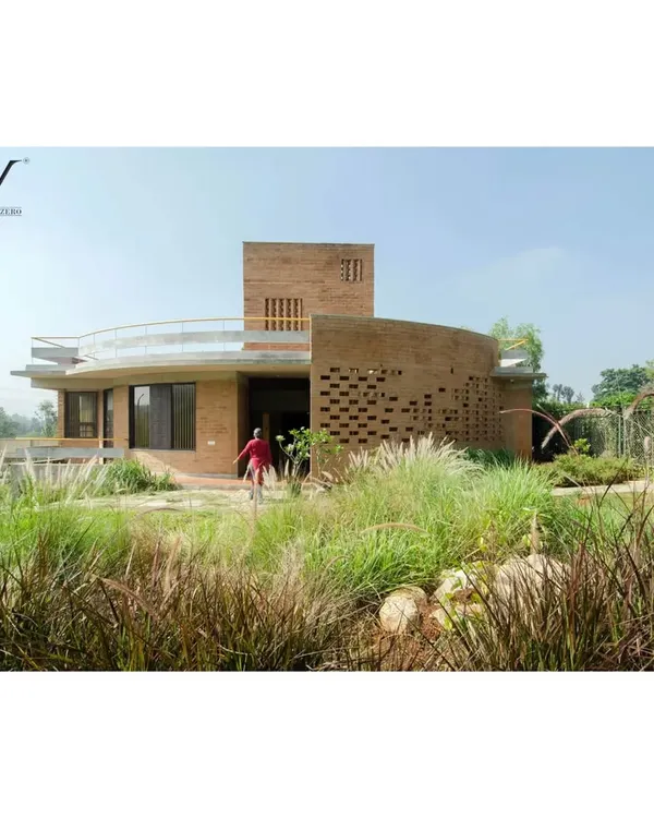 The 'Breathe' residence, where the structure is designed as a living, breathing skin. The building, with its perforated earth-block walls, is enveloped by a native landscape of wild grasses, demonstrating how architecture and nature can exist in true companionship.