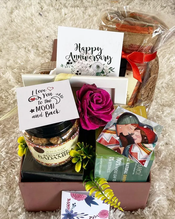 Celebrate your journey together with a romantic anniversary hamper. This gift box is filled with love, featuring sugar-free sweets, a "Happy Anniversary" card, a personal "I Love You to the Moon and Back" note, and other curated items to make your special day even more memorable.