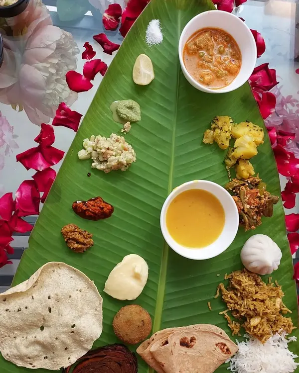 This is what a true Maharashtrian feast looks like. Our hamper includes over 18 traditional vegetarian dishes, from savory snacks like Kothimbir Wadi to classic sweets like Ukadiche Modak, all arranged for a traditional banana leaf meal.