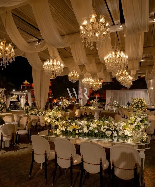 For this destination wedding, I created a dreamscape of draped ivory canopies and over 40 cascading chandeliers. The entire space glowed, with mirror-finish tables reflecting the light and the abundance of white roses and orchids.