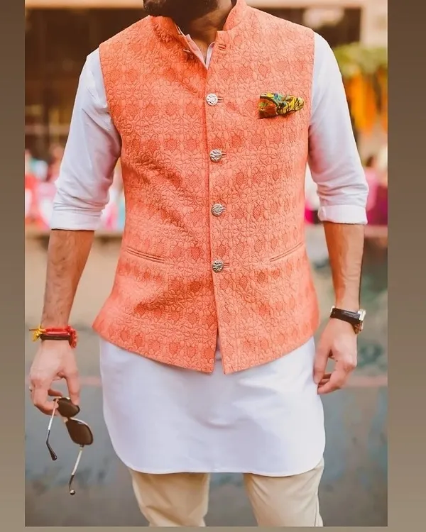 A great example of a modern ethnic look. I tailored this peach-colored Nehru jacket with a subtle woven pattern to be worn over a simple white kurta for a fresh, stylish outfit.