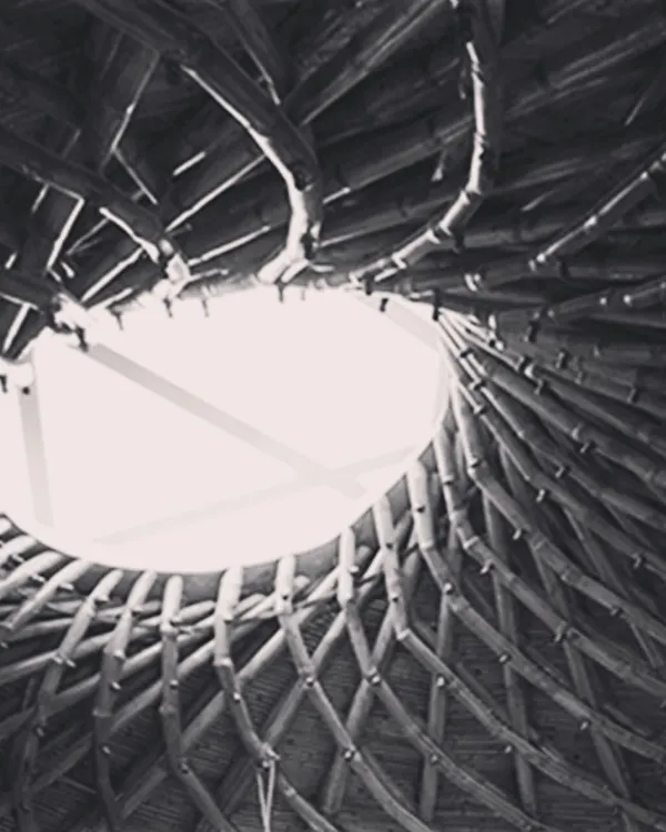 The completed bamboo roof of a yoga hall, seen from below. The intricate spiral weave is not just beautiful but also structurally sound, creating a breathtaking canopy with a central oculus that lets in natural light.