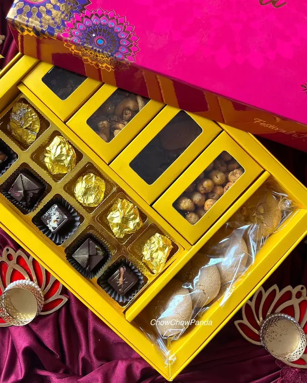 This is one of my premium Diwali hampers. It includes a section of assorted foil-wrapped chocolates, compartments for nuts, and a package of homemade cookies.