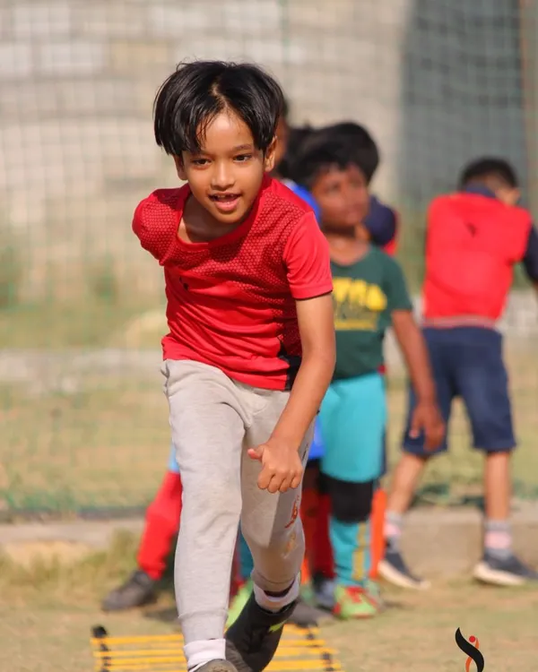 The focused energy of our summer camp. This young player gives his all during an agility drill.