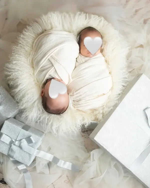 Twice the love, twice the joy. This newborn twin photoshoot features the babies swaddled peacefully together, surrounded by gift boxes to symbolize the precious gifts they are.