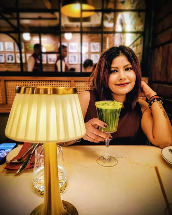 A quiet moment during a birthday dinner. This simple, sleeveless maroon dress is an elegant and timeless choice for a special evening celebration.