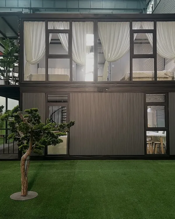This two-story container home is a perfect example of stylish, sustainable living. The design features large glass windows for natural light and a second-floor balcony, all built within a strong steel frame.