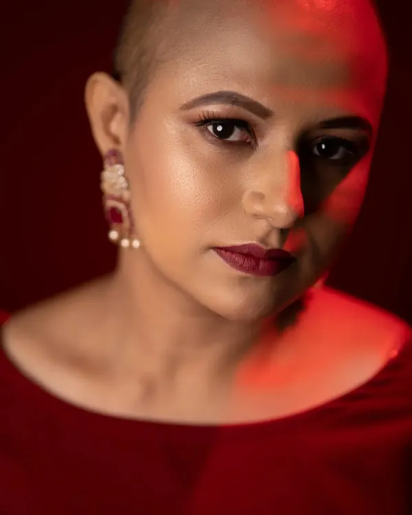 This powerful look celebrates beauty in all its forms. The focus is on a flawless skin base with a subtle glow, sharp contouring, and a bold matte red lip that complements the rich red attire.