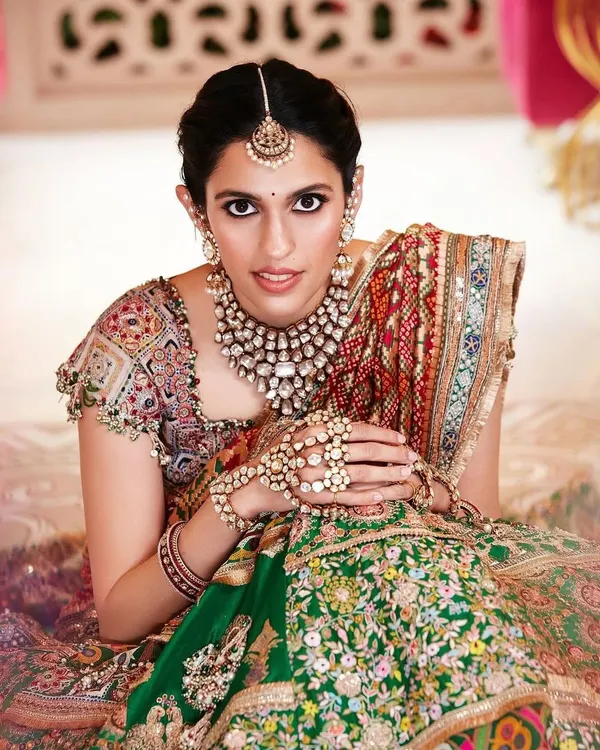 This custom Anamika Khanna lehenga is one of my all-time favorites. The blend of green and red with intricate, multi-colored embroidery and a stunning dupatta makes it a true masterpiece for a bride.