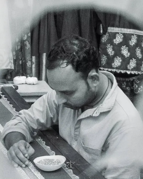 An artisan at work, meticulously hand-embroidering a design. This is where the magic happens, stitch by stitch.