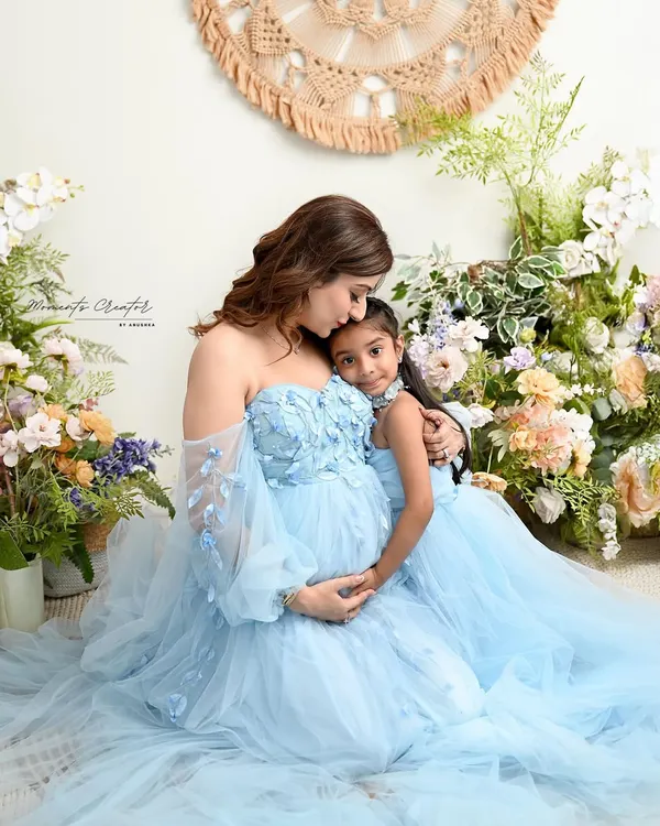 A quiet moment between a mother and her daughter, both sharing in the excitement of the new baby to come. Twinning in these beautiful blue gowns makes the portrait even more special.