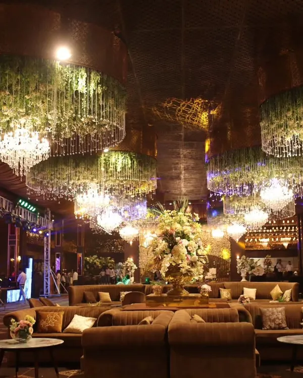 A wide view of a magnificent event hall I catered. The combination of grand floral chandeliers and plush lounge seating creates an opulent and inviting atmosphere for a memorable celebration.