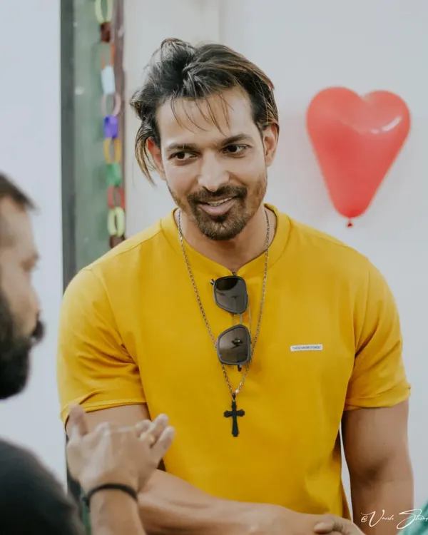 A candid shot of actor Harshvardhan Rane interacting with someone off-camera, capturing a natural and engaging moment.