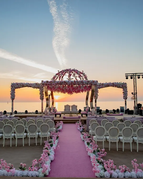 A breathtaking sunset mandap set against the serene expanse of the sea. We specialize in creating these once-in-a-lifetime destination wedding experiences, where every detail, from the floral dome to the seating, is designed to complement the natural beauty of the location.