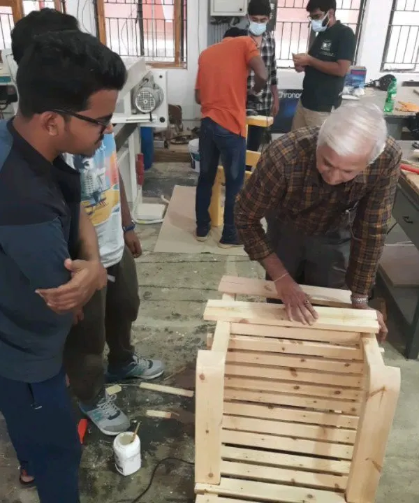 Our chief trainer works closely with diploma students, guiding them through the assembly of a slatted chair. This direct mentorship is key to helping students overcome challenges and refine their techniques.