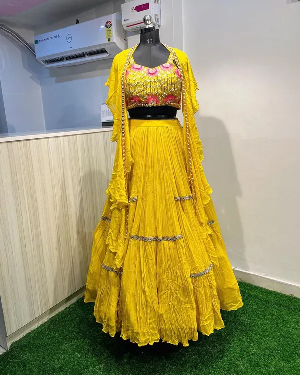 This bright yellow tiered lehenga comes with a stylish cape-style jacket. It's a modern and comfortable rental choice for a Haldi ceremony, allowing you to move and dance freely.