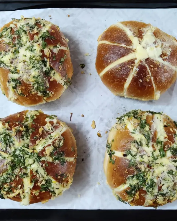 A tray of freshly baked Korean Cream Cheese Garlic Buns. You can see the generous garlic and herb topping over the golden-brown crust, with the cream cheese filling peeking through.