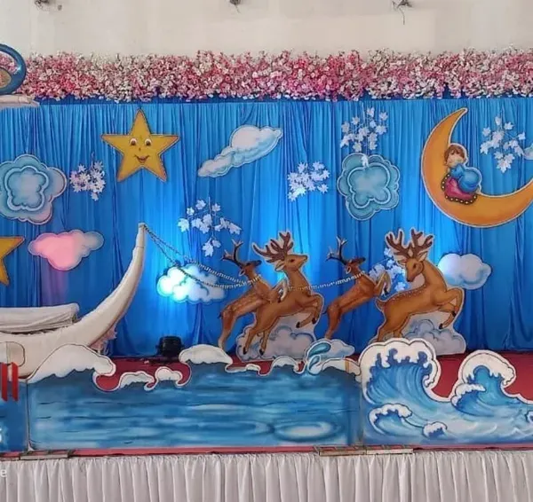 A whimsical 'Dohale Jevan' (baby shower) setup with a celestial theme. We created the moon-shaped seat for the mother-to-be, along with cutouts of stars, clouds, and reindeer to create a dreamy atmosphere.