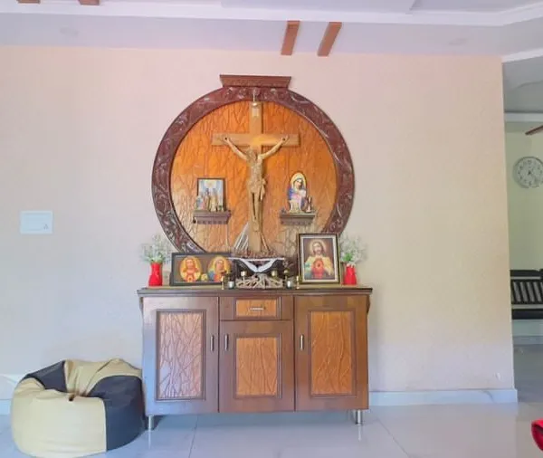 This is the 'before' shot of a living room altar space. A plain wall like this is a perfect canvas, holding the potential to become a deeply personal and artistic centerpiece for the family's home.