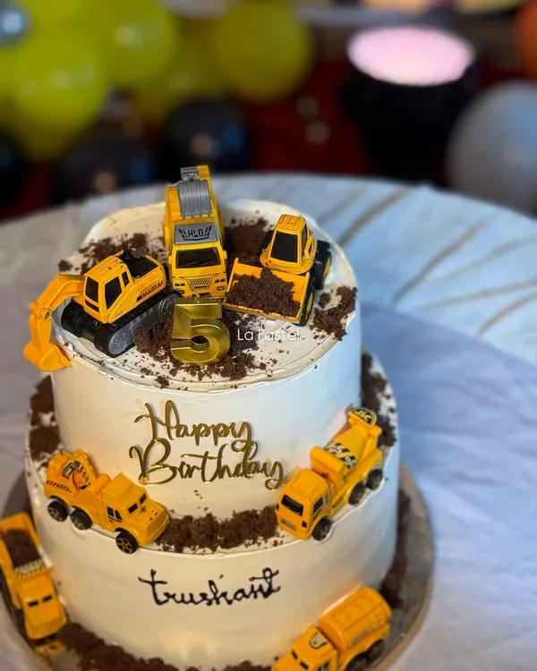 This two-tier construction theme cake is ready for some serious fun! It's decorated with toy excavators and dump trucks digging into a 'dirt' path made of crushed chocolate cookies.