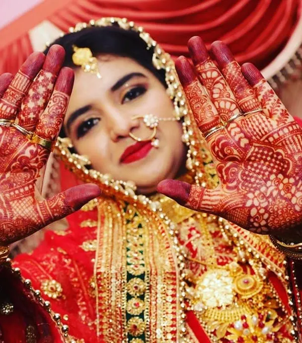 The joy on a bride's face and the beautiful red stain of her henna is what makes my work so rewarding. This professional shot shows how the mature henna stain looks on the wedding day.